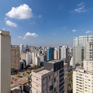 Une vue urbaine avec de hauts immeubles, un ciel dégagé et quelques nuages.