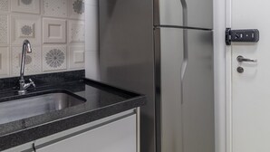 A stainless steel refrigerator in a kitchen with a black countertop and a sink. - Ycp2307 in S o Paulo (São Paulo)