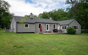A single-story house with a covered patio area, a chimney, and a small front yard.