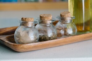 Three glass bottles with cork stoppers on a wooden tray.