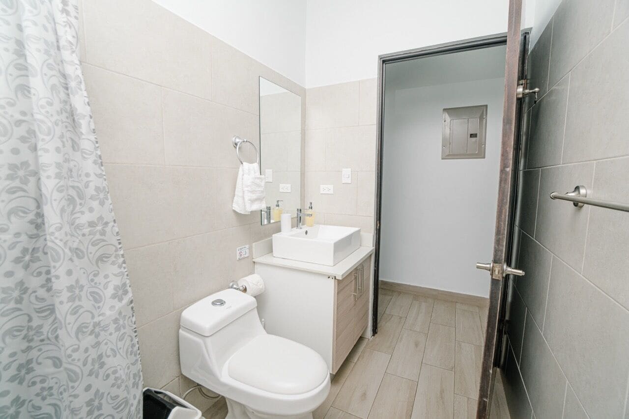 Ein modernes Badezimmer mit Toilette, Waschbecken und Spiegel.