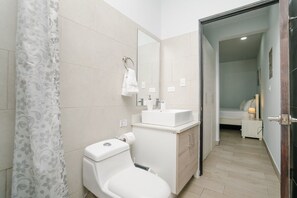 A modern bathroom with a toilet, sink, and mirror.
