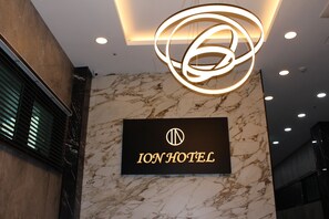A sign for the Ion Hotel with a modern, circular light fixture above it. - ION HOTEL DONGDAEMOON (Seoul)