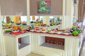 A buffet with various food items and a mirror reflecting the room.
