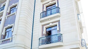 A hotel entrance with a curved facade, multiple balconies, and a prominent 'CAFITOL HOTEL' sign.