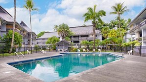 A swimming pool surrounded by palm trees and a building with balconies. - Hilo Lakefront Studio, Pool, Walk to Downtown (Hilo)