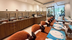 Un comedor moderno con una barra larga, bufé y sillas de cuero.