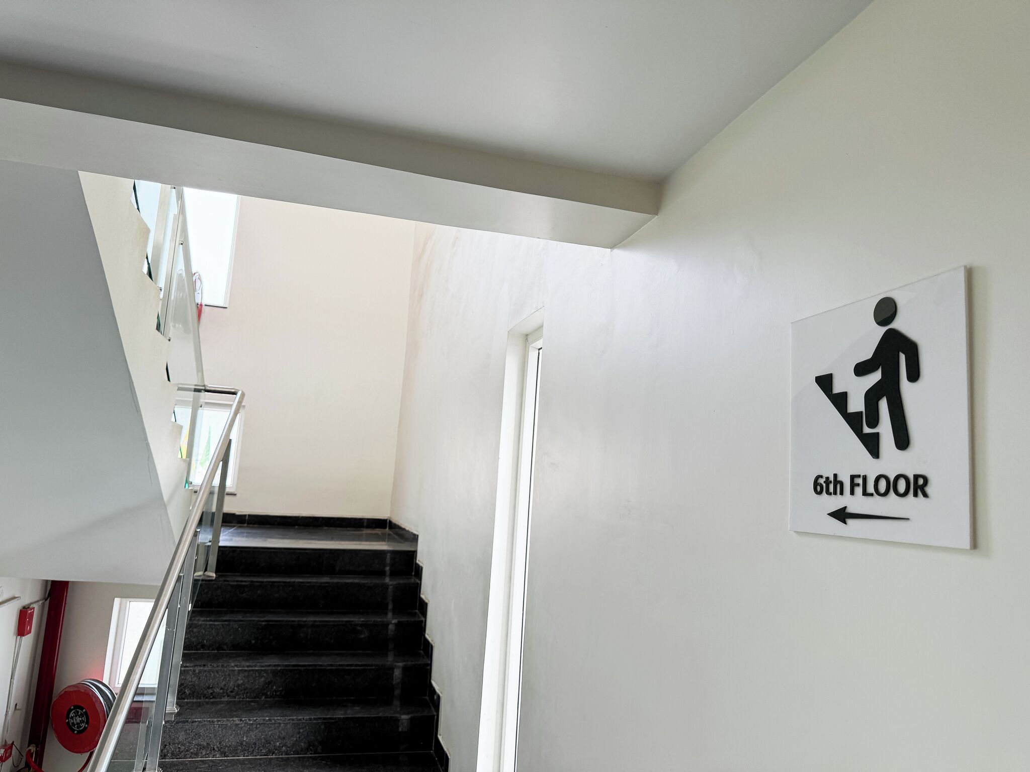 A staircase leading to the 6th floor with a directional sign.