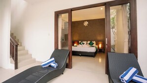 A hotel room with a bed, a small desk, and two lounge chairs. - Taman Bali Villa Kerobokan (Kerobokan)