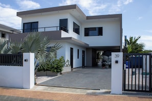 A modern two-story house with a gated entrance, a driveway, and a number 39 sign. - Villa - Sleeps 8 with Pool and Seaview (Willemstad)