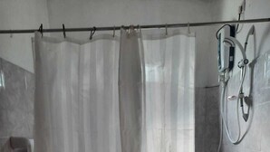 Ein Badezimmer mit Toilette, einer Duschvorhang und einer Handbrause.