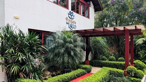 A building with a white exterior, a red roof, and a sign reading "POUSADA DO LAGO". - Pousada do Lago Gramado (Gramado)