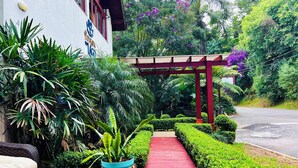 A well-maintained outdoor area with a red pathway leading to a building marked with a number. - Pousada do Lago Gramado (Gramado)