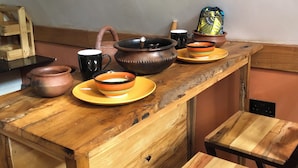 Una mesa de madera rústica con varios platos de cerámica y un hervidor.
