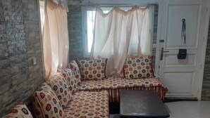 A living room with a sofa set, a coffee table, and a door with a coat hanging on it. - Captivating 4-Bed House in Tamaris (Tamaris)