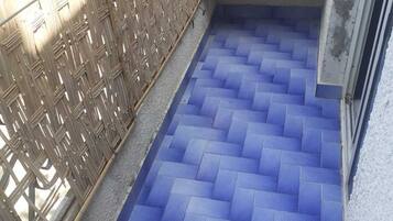 A staircase with blue-tiled steps leading to a landing area.