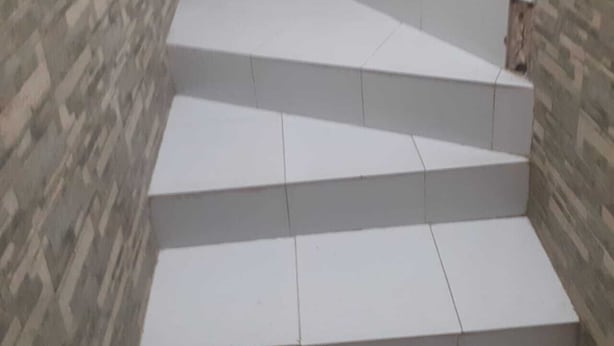 A set of white steps leading up to a landing area with a patterned wall. - Captivating 4-Bed House in Tamaris (Tamaris)