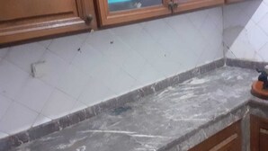 A kitchen with wooden cabinets, a marble countertop, and a tiled backsplash. - Captivating 4-Bed House in Tamaris (Tamaris)