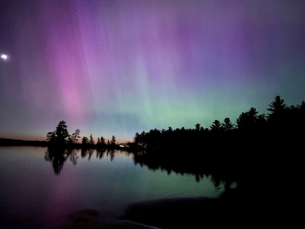 Un paisaje nocturno con un lago tranquilo que refleja el cielo.