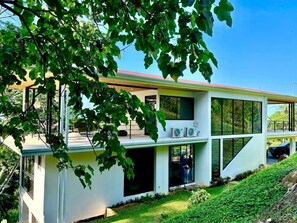 Una casa moderna de dos pisos con amplios ventanales y techo plano.