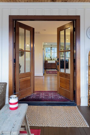 A wooden door leading to a kitchen with a rug at the entrance.