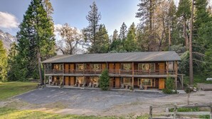 A two-story lodge with a central patio and multiple windows. - Bear's Den Camp Nelson Lodge #5 (Springville)