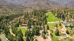 A residential area with houses, a golf course, and a forested mountain backdrop. - Bear's Den Camp Nelson Lodge #5 (Springville)