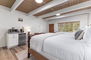 Une chambre à coucher avec un lit, une table de chevet et une fenêtre donnant sur un beau paysage.