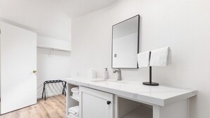 A modern bathroom with a white vanity, a large mirror, and a towel rack. - Timberline Retreat Camp Nelson Lodge #3 (Springville)