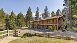 A wooden lodge with a covered porch and a staircase leading to the upper level. - Timberline Retreat Camp Nelson Lodge #3 (Springville)