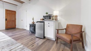 A compact kitchen with a microwave, refrigerator, and a small cabinet. - Camp Nelson Lodge | Room 4 | Sierra Nevada Retreat (Springville)