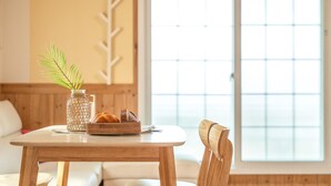 A wooden table with a woven basket containing bread and a vase with a plant. - Gapyeong Gold Castle Pension (Gapyeong)
