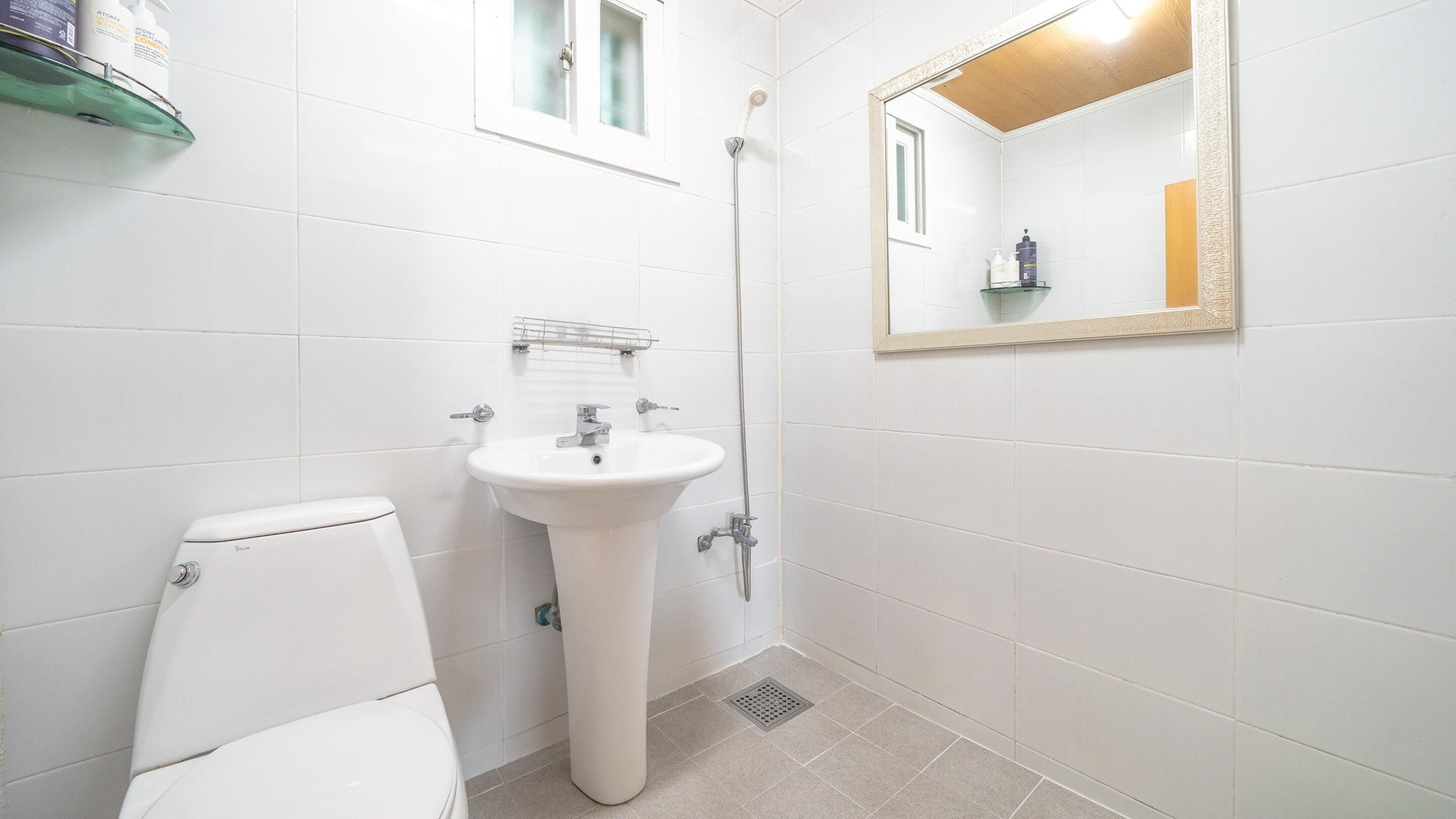 Ein kleines, sauberes Badezimmer mit Toilette, Waschbecken und Dusche.
