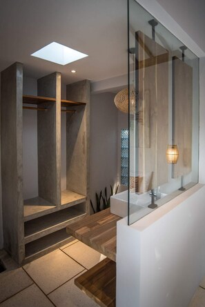 Ein modernes Badezimmer mit großem Spiegel, freistehender Badewanne und Dachfenster.