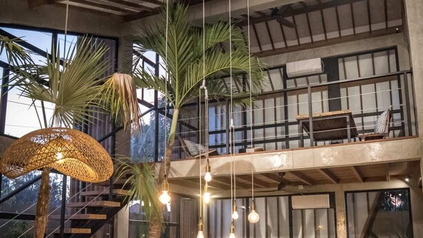 A modern dining area with a long table set for a meal, surrounded by chairs. - Villa Nina (Canggu)