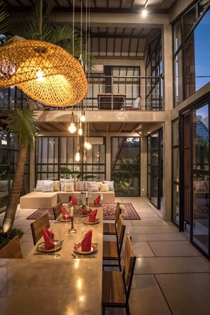 Enjoy meals in this dining area with a long table, balcony views, and comfortable seating.