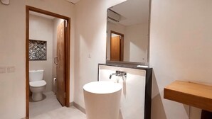 A bathroom with a toilet, a sink, and a mirror. - dBeds Kuta Beach (Kuta)