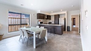 Una cocina moderna con comedor, un ventanal y vista al jardín trasero.