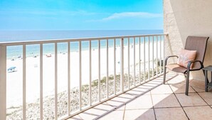 Ein Balkon mit Blick auf Strand und Meer.