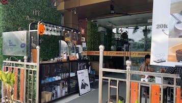 A coffee shop with a green wall, a sign for 'Anugrah Inn', and a '20k' sign.