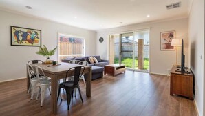 A spacious living area with a dining table, chairs, a sofa, and a TV stand. - Homely Entire house in Clyde (Clyde)