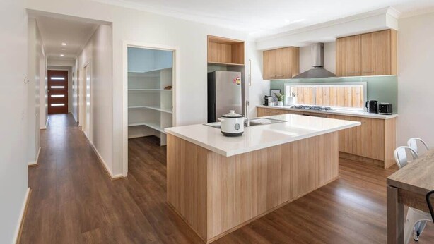 A modern kitchen with a central island, wooden cabinets, and a built-in stove. - Homely Entire house in Clyde (Clyde)