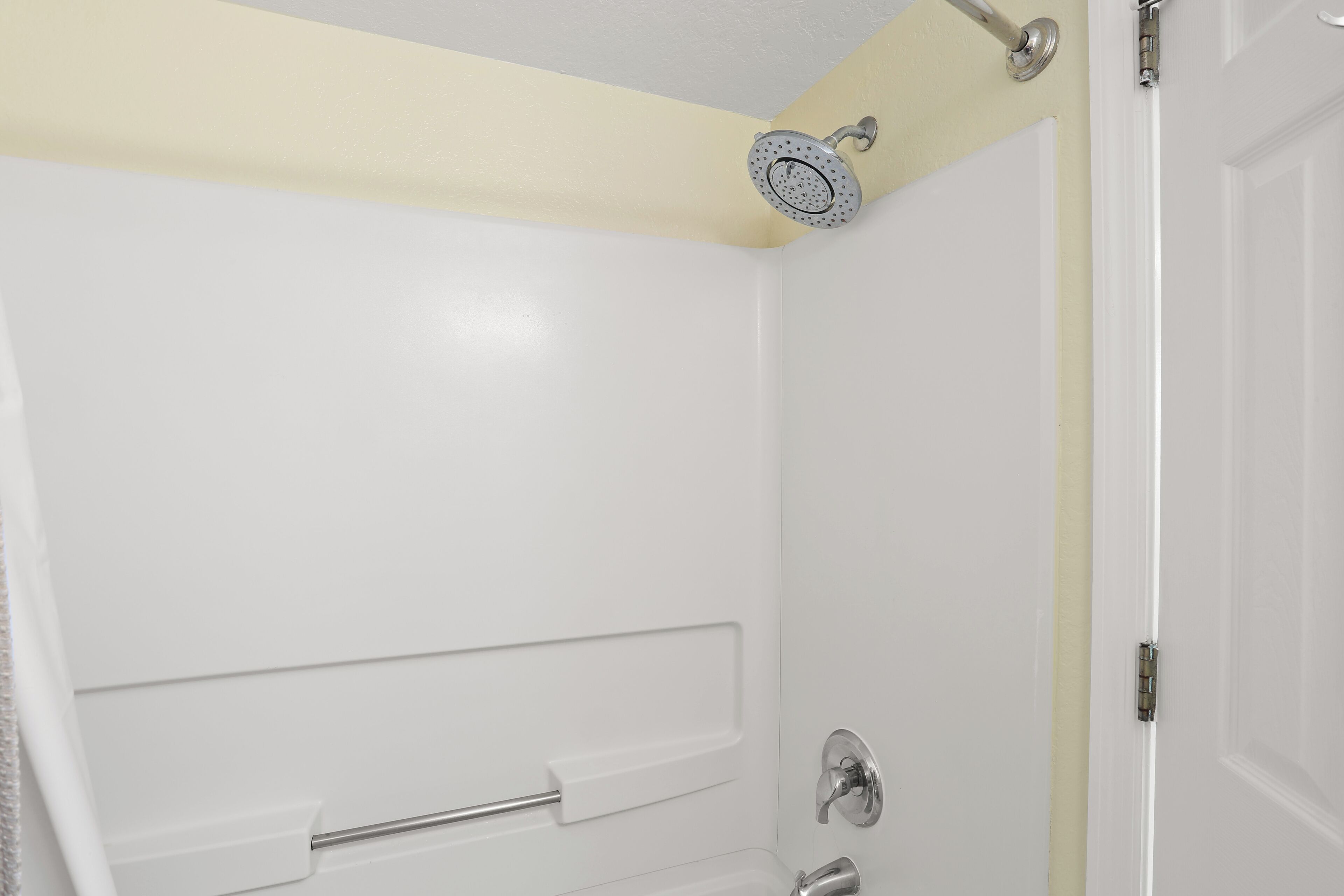 Un baño con ducha, toallero y puerta.