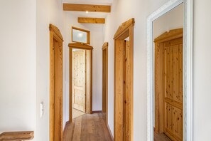 A hallway with wooden doors and a wooden bench.