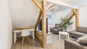 Una habitación estilo loft con escritorio, silla, sofá y una pequeña mesa.