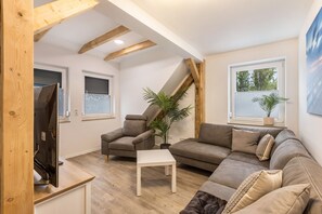 Un salon moderne avec un canapé, un fauteuil et une petite table blanche.