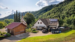 A rural setting with a church, a house with solar panels, and a garage.