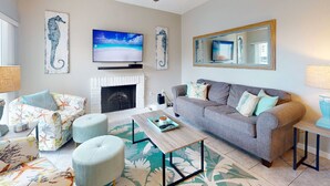 Una sala de estar con chimenea, televisor y sofá.