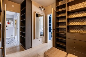 Relax in a spacious room with a walk-in closet, full-length mirror, and comfortable seating area.