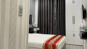 Een moderne hotelkamer met een bed, bureau, kast en een badkamer.